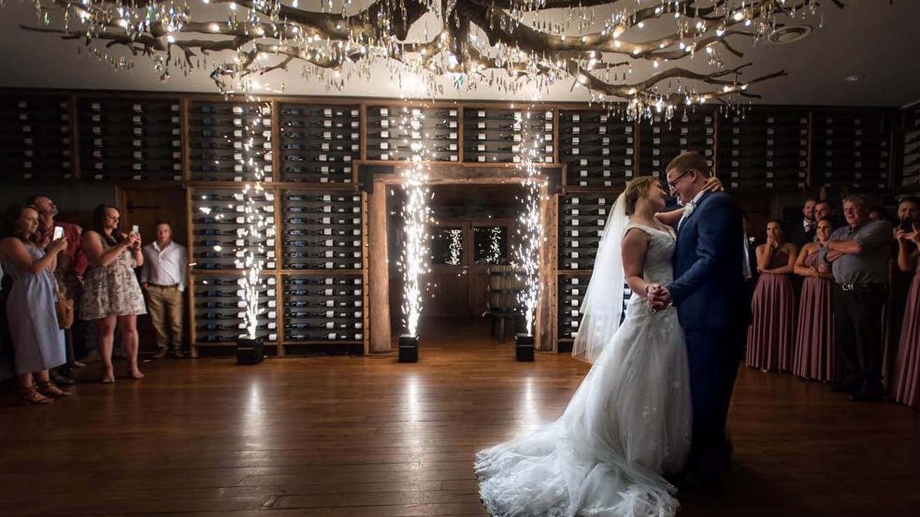 Bride and groom dancing with indoor cold sparks during their wedding reception.